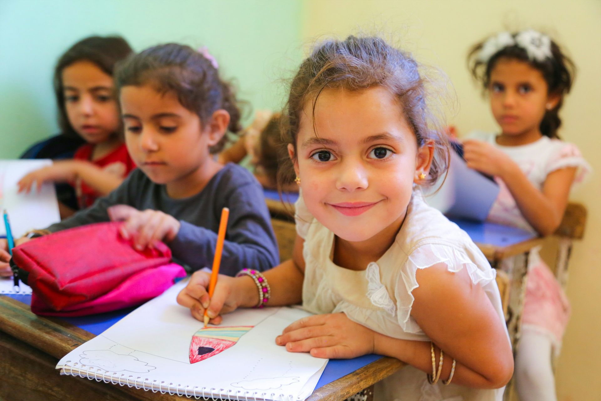 A group of young children sitting at a desk